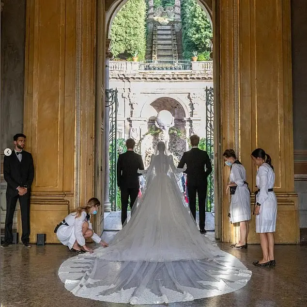 Kitty made her grand entrance in a Victorian-inspired ivory lace gown and Cathedral-style veil