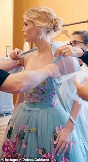 The evening before the main event, Kitty captivated guests in a blue tulle dress, featuring a corseted bodice, full skirt and floor-length cape embroidered with blooms