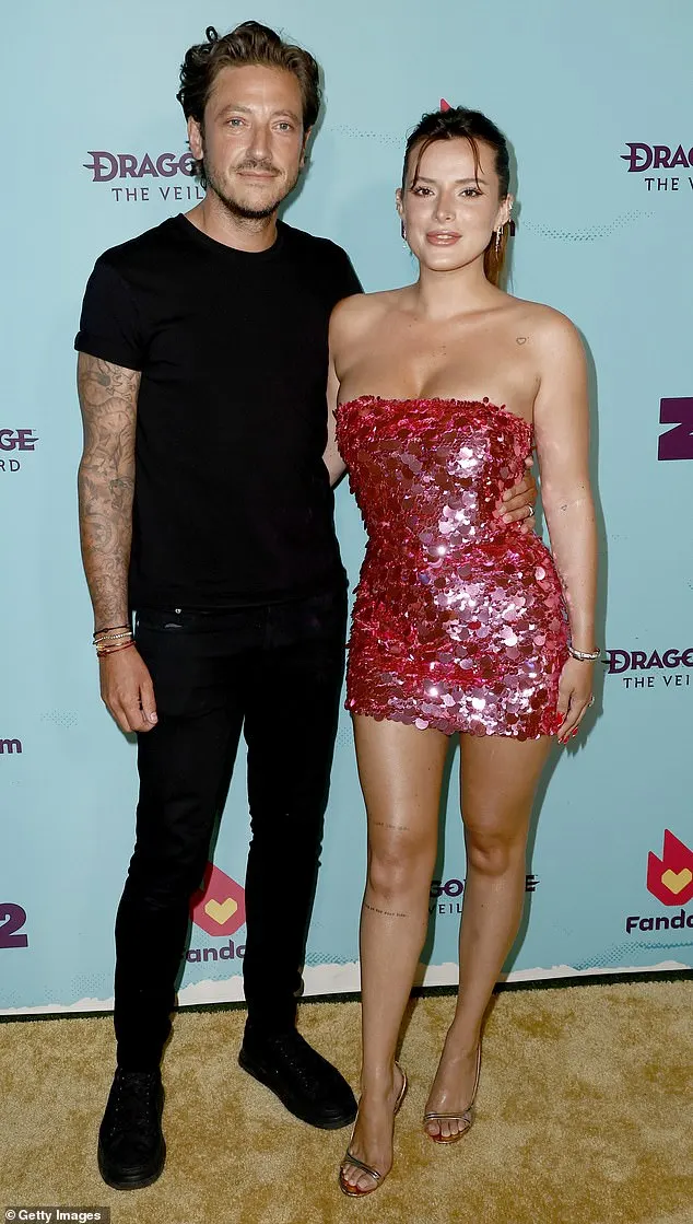 Bella Thorne, 26, put on a leggy display in sequined pink mini dress and towering stilettos as she cosied up to fiancé Mark Emms, 45, on Thursday on the red carpet of Fandom's party