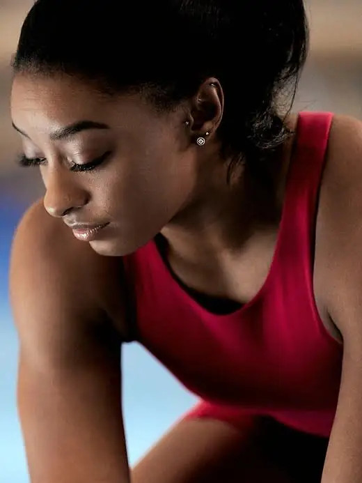 Simona is sporting a dark athleta grain sports bra tank in simone biles.