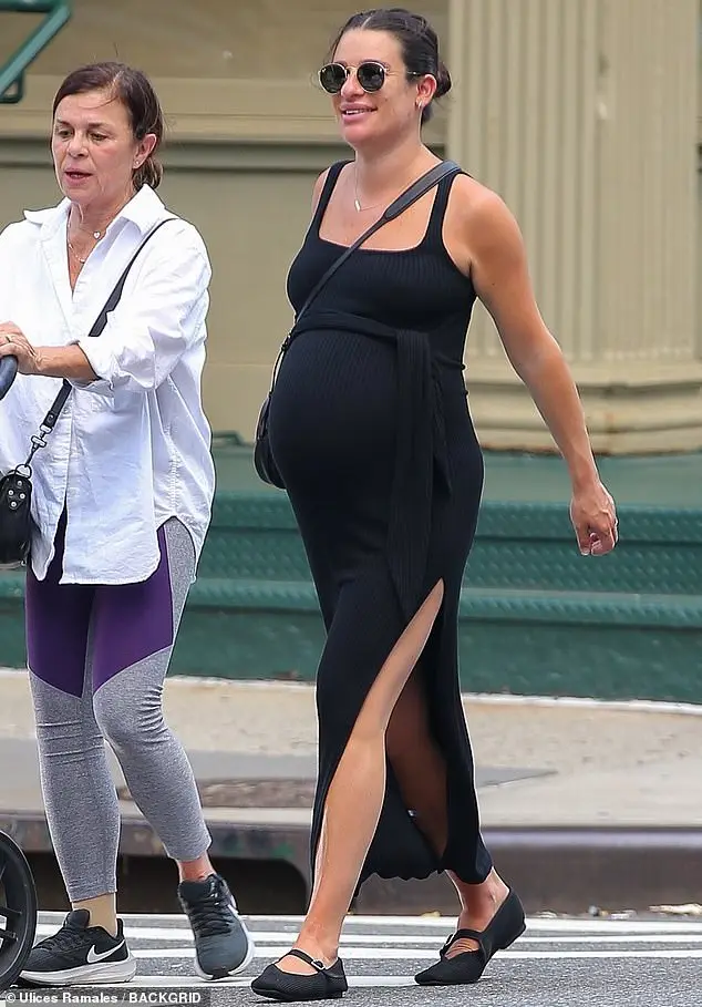 Lea Michele draped her blossoming baby bump in a flowing black dress as she stepped out in New York City with her mother Edith Sarfati this week