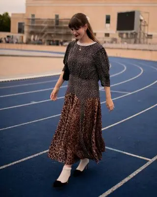 senior fashion editor Halie LeSavage wears a mixed print rixo dress and manolo blahnik heels while walking down the track to the baum und pferdgarten show