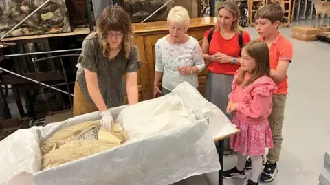 York Museums and Galleries Jennifer Slater with daughter Christina Bromley as well as Lily’s great, great grandson Alexander and great, great granddaughter Emmeline viewing the wedding dress