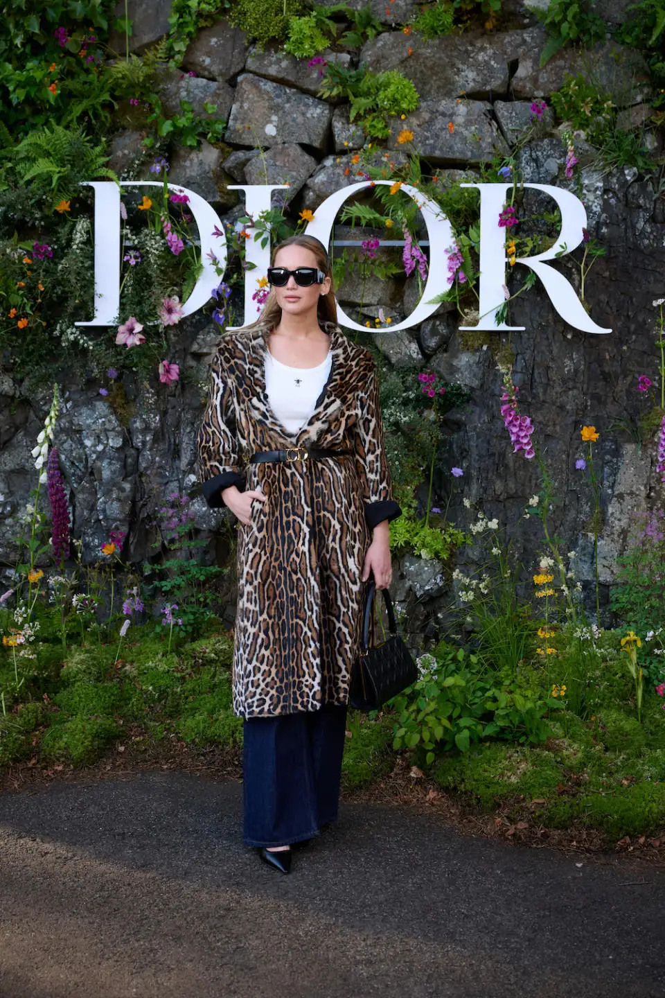 In front of a christian sign, Jennifer Lawrence sports a leopard print coating and tank top.