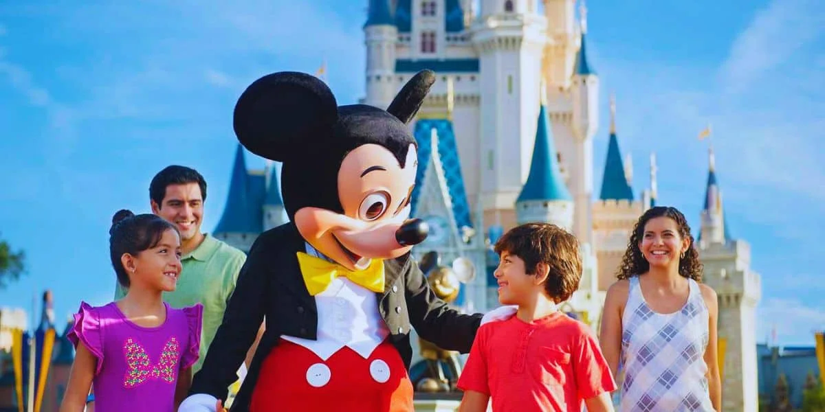 Mickey Mouse in front of the Cinderella Castle inside the Magic Kingdom with a couple of children