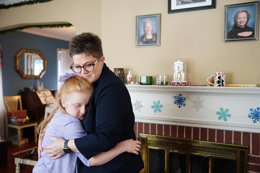 Astrid Burkle, 11, hugs her mom Alicia inside their Cleveland Heights home.