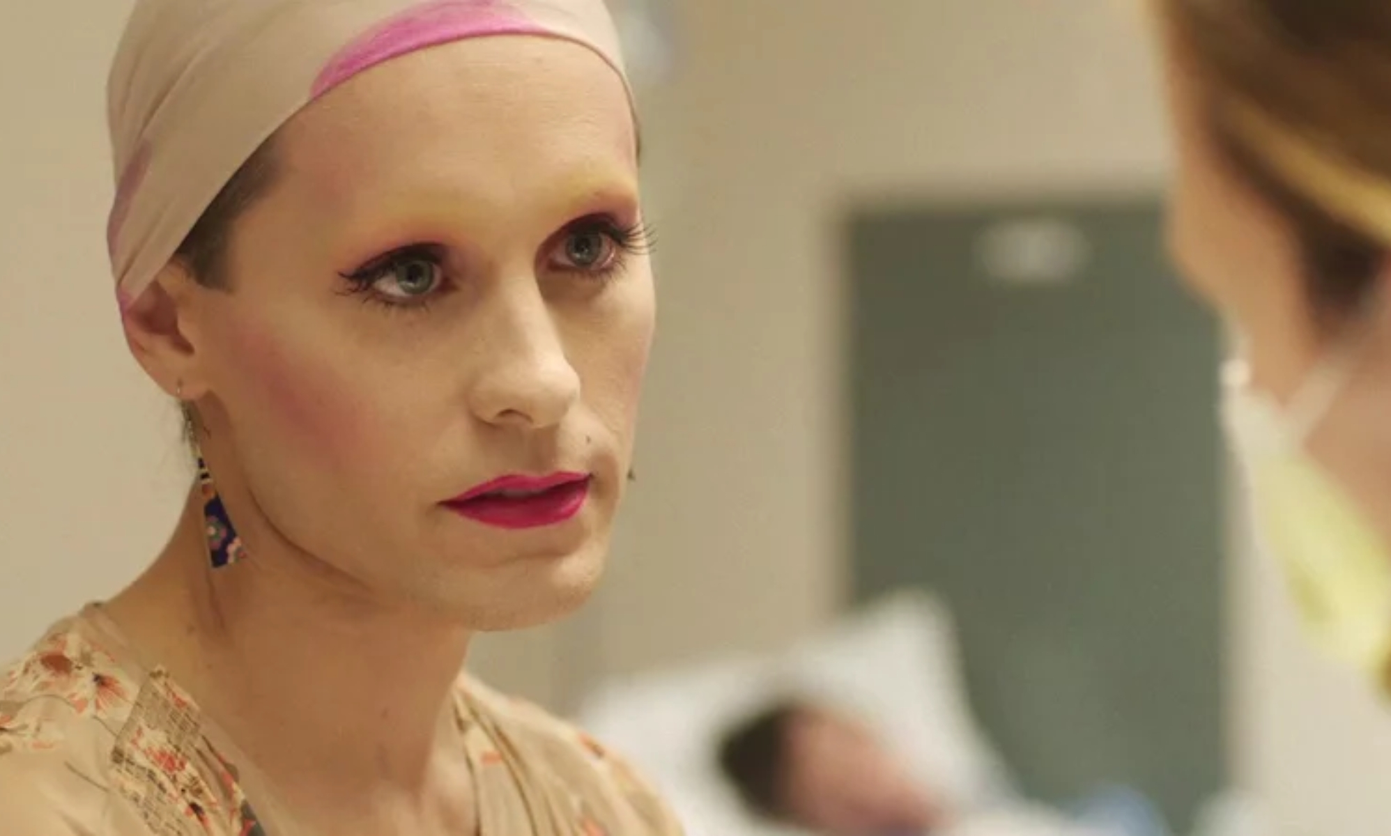 Jared Leto as trans woman Rayon in Dallas Buyers Club wearing make up with a cream and pick scarf over their hair.