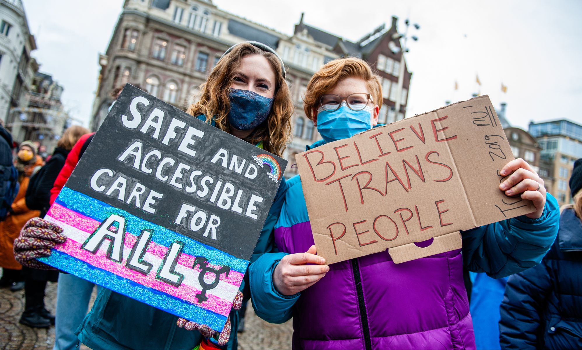 Two people hold placards in support of trans healthcare during a protest in Amsterdam on 6 February 2022