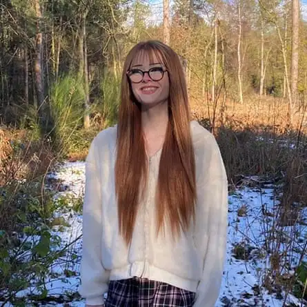 Family photo of Brianna Ghey standing smiling outdoors in a wooded area