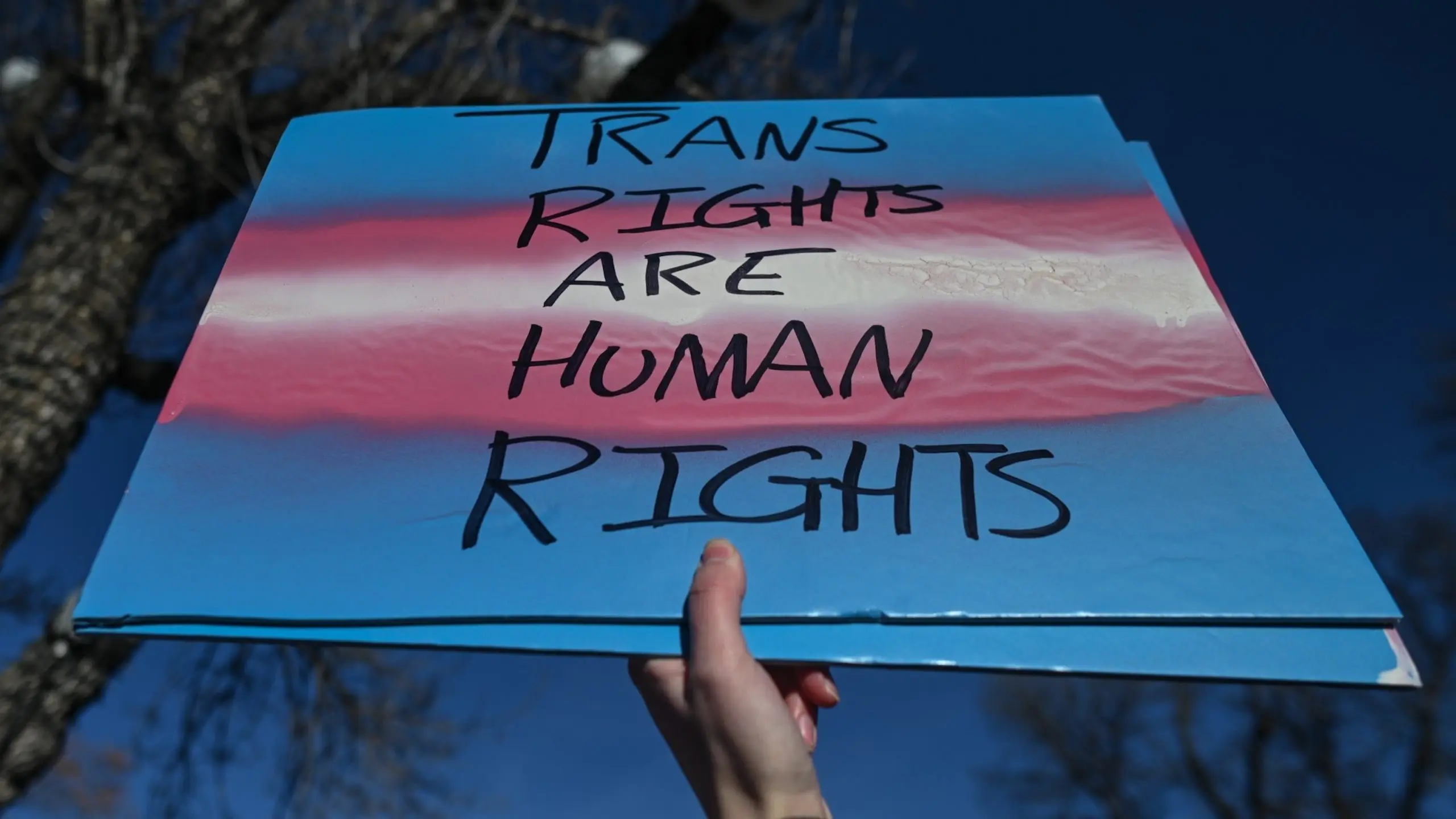 PHOTO: An activist holds a poster as hundreds of people gather to protest Premier Danielle Smith's proposed LGBTQ2S+ legislation and opposing legislation affecting transgender and non-binary youth, Feb. 3, 2024, in Edmonton, Alberta, Canada.