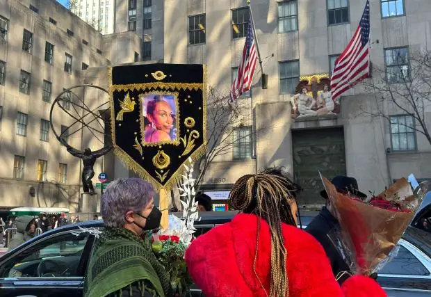 People with flowers and Cecilia Gentili's photo are pictured Thursday, Feb. 15, 2024, outside St. Patrick's Cathedral in Manhattan. (Sheetal Banchariya for New York Daily News)