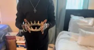 A person holds a crown.