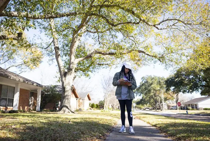 Lauren Ashley Simmons checks addresses of voters as she block walks on in Houston.