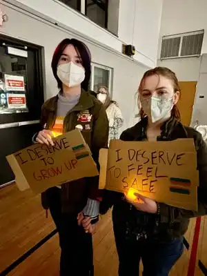 From left, Charly Heinrich, 16, and Em Day, 17, from Wachusett Regional High hold signs at the vigil for Nex Benedict Friday at the YWCA in Worcester