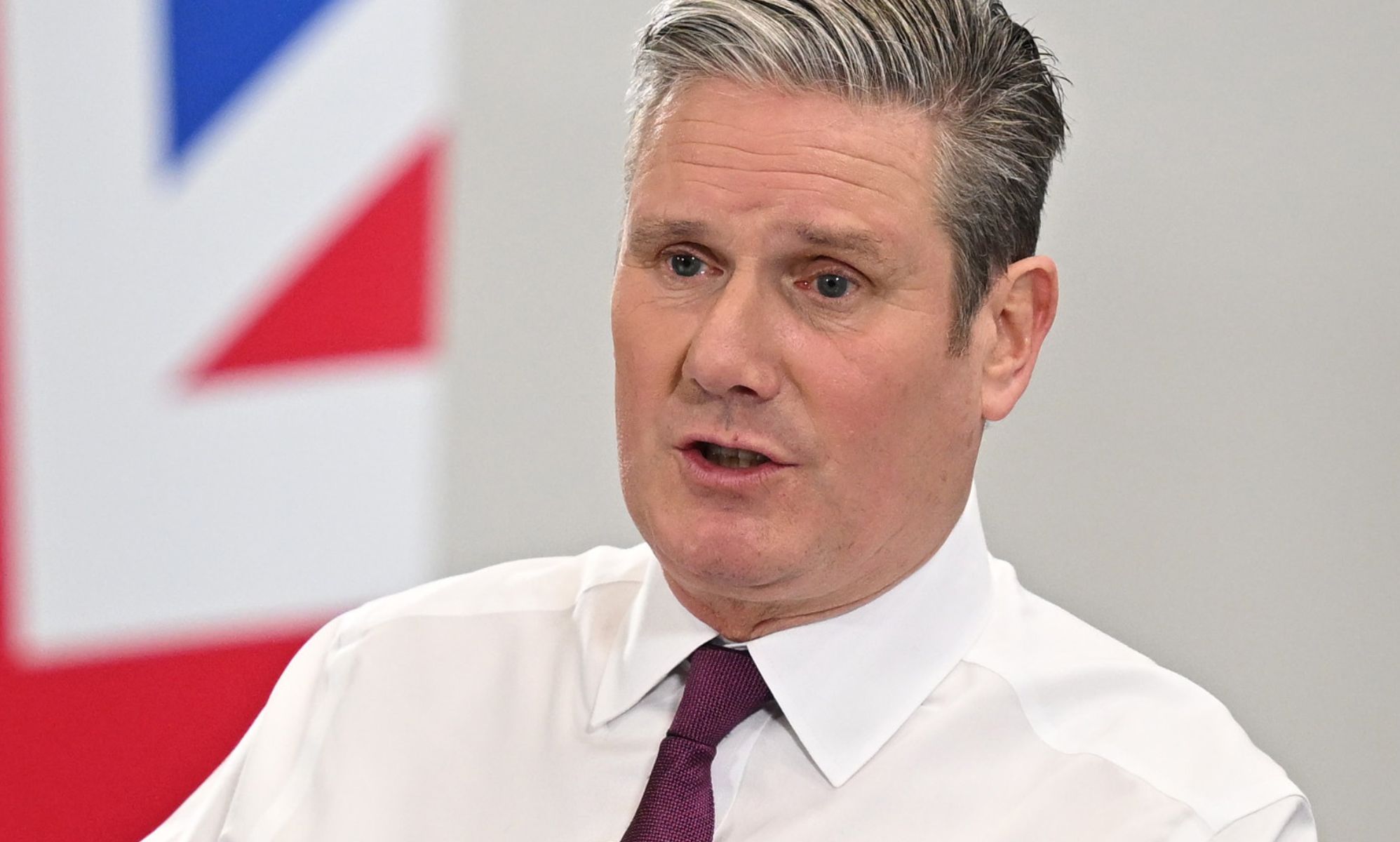 Keir Starmer speaks infront of a UK flag.