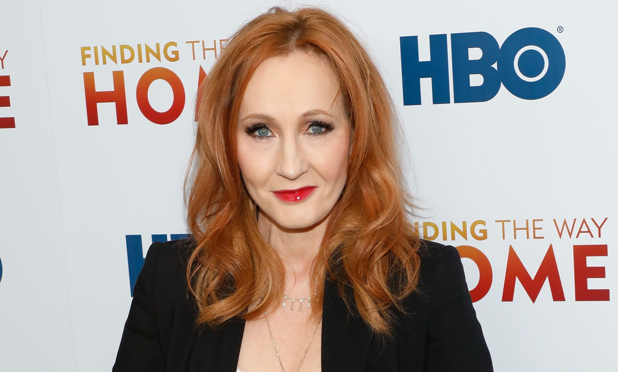 Harry Potter author JK Rowling looks towards the camera while wearing a black blazer at a press event