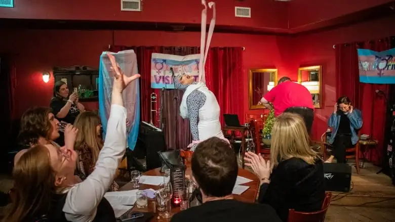 A drag queen performs in a crowd.