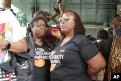 Human rights activists stand outside the Constitutional Court in Kampala, April 3, 2024, as Uganda's Constitutional Court gives its seal of approval on the anti-homosexuality law.