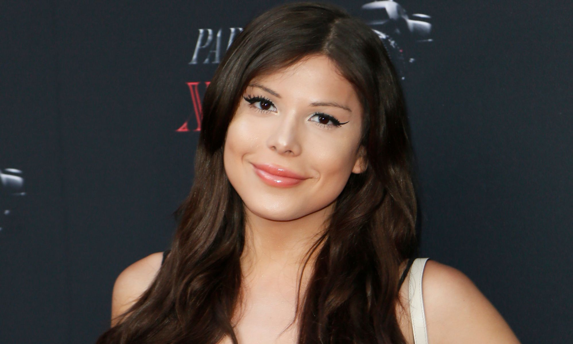 Blaire White smiles during a red carpet event.