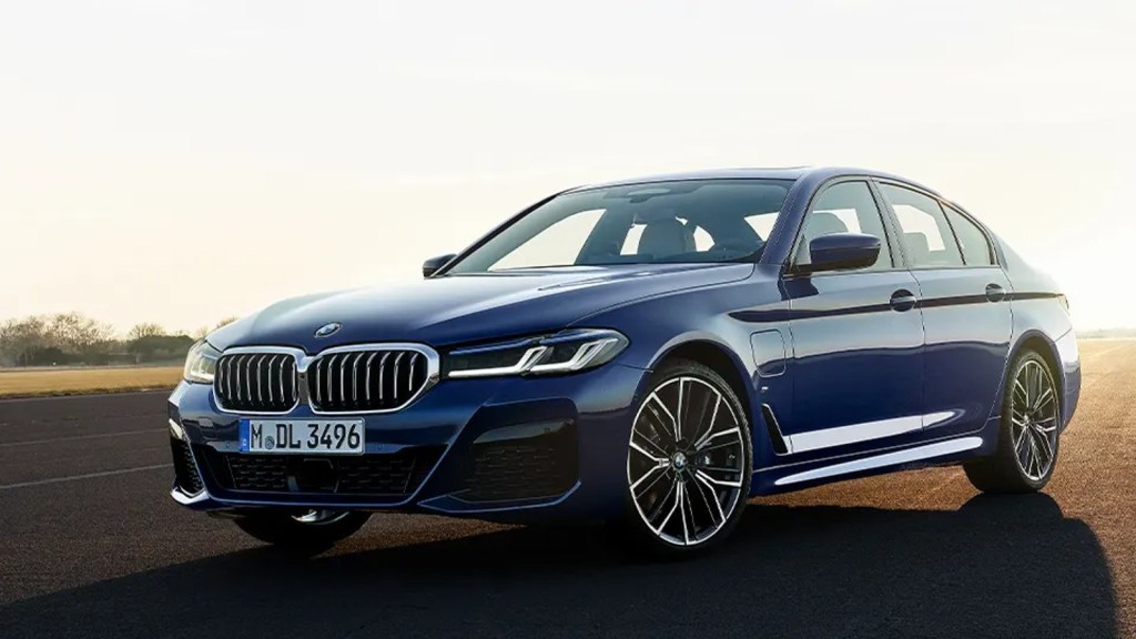 Blue BMW 5 Series driving on a road. This popular luxury car is one of the lowest-rated in terms of five-year cost of ownership.