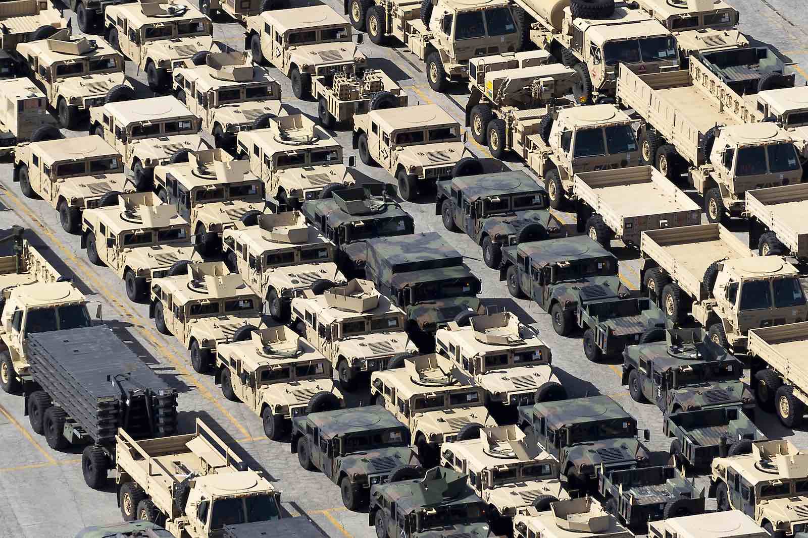 Parking lot full of surplus military vehicles.