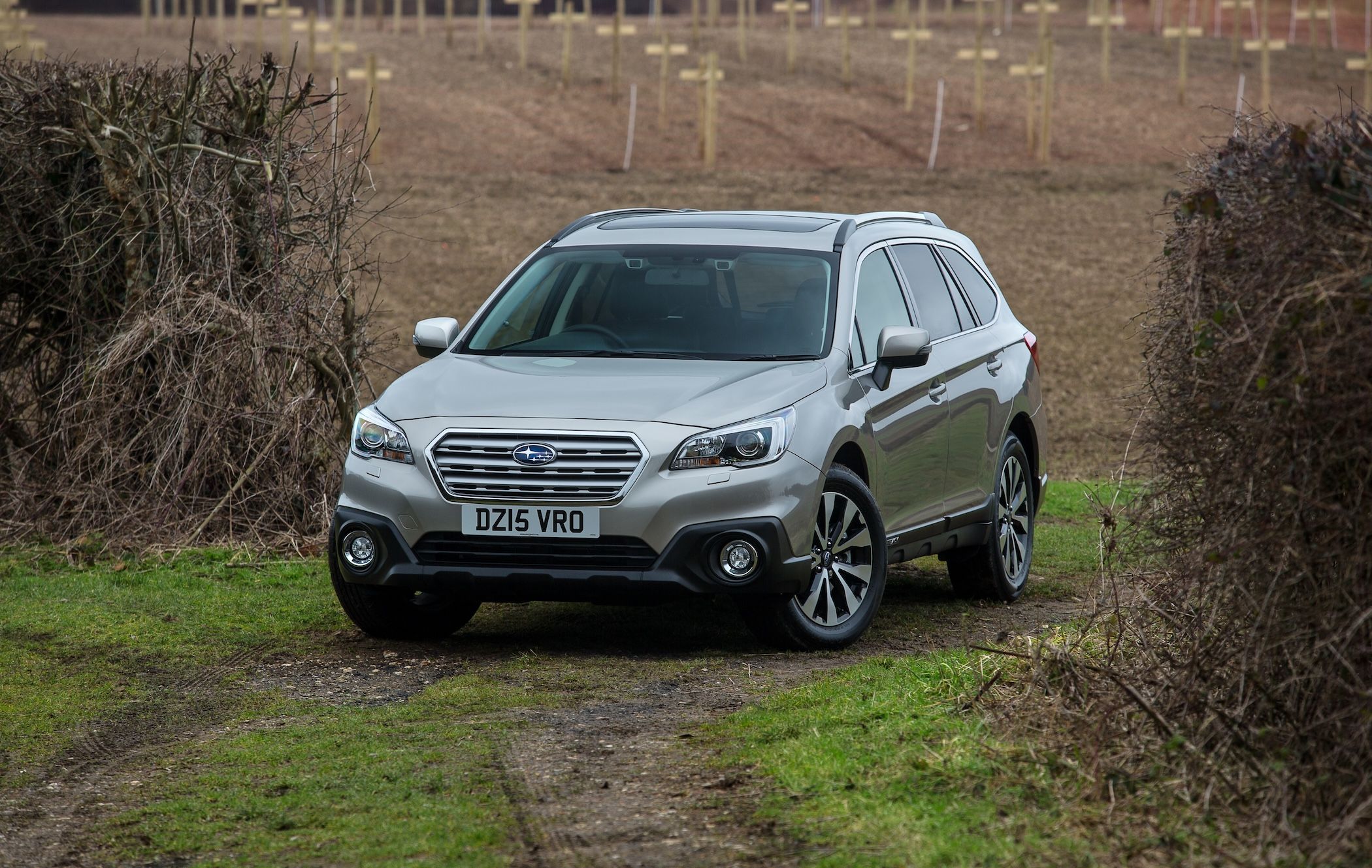 Silver Subaru Outback parked in field