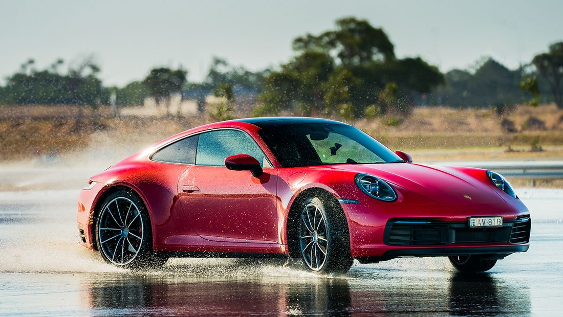 a red Porsche 911 992 drifting on water