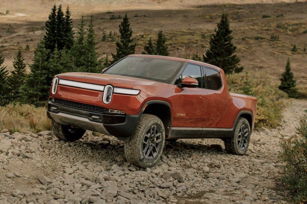 The 2024 Rivian R1T climbing over rocks