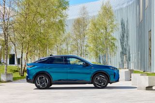 Peugeot E-3008 side view with trees and contemporary building behind