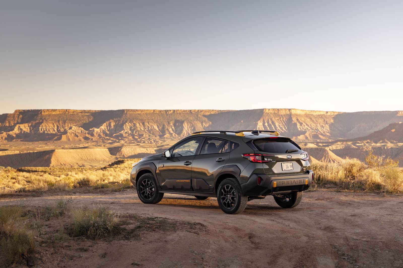 Green Subaru Crosstrek SUV parked off road.