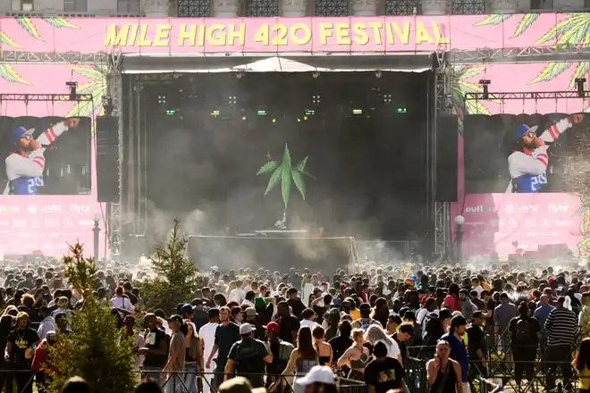 A cloud of smoke rises over people smoking while rapper Lil Jon performs during the Mile High 420 Festival in Denver, Colo., on April 20, 2022, known by some as 'Weed Day'. Tens of thousands of cannabis enthusiasts gathered in Denver on April 20 to celebrate the ever-widening US legalization of recreational weed with plumes of pungent smoke, music... and a few grumblings about commercialization. April 20 has become the national holiday for the herb in the United States, as the date corresponds with the 