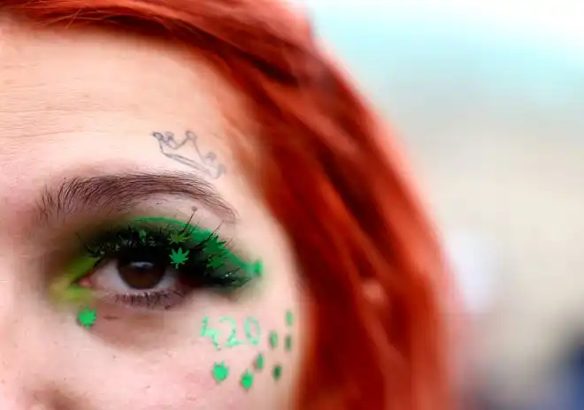 A woman participates in a gathering along with marijuana activists to mark the annual world cannabis day and to protest for legalization of marijuana, in front of the Brandenburg Gate, in Berlin, Germany, April 20, 2022.