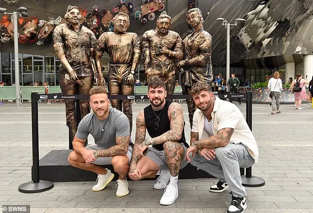 Three of the 'four lads in jeans' squatted down in front of their new statue for a few promotional snaps