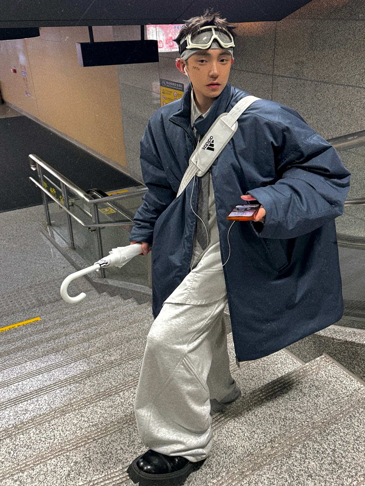 korean men's fashion: Dark Oversized Jacket + Light Gray Baggy Pants + White Crossbody Bag + Black Chunky Shoes + Goggles