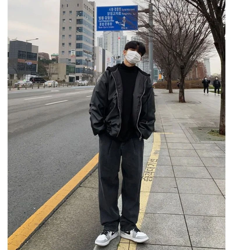 Korean Men's fashion: Oversized Black Leather Jacket Layered Over A Classic Black Turtleneck + Loose-Fitting Charcoal Gray Trousers