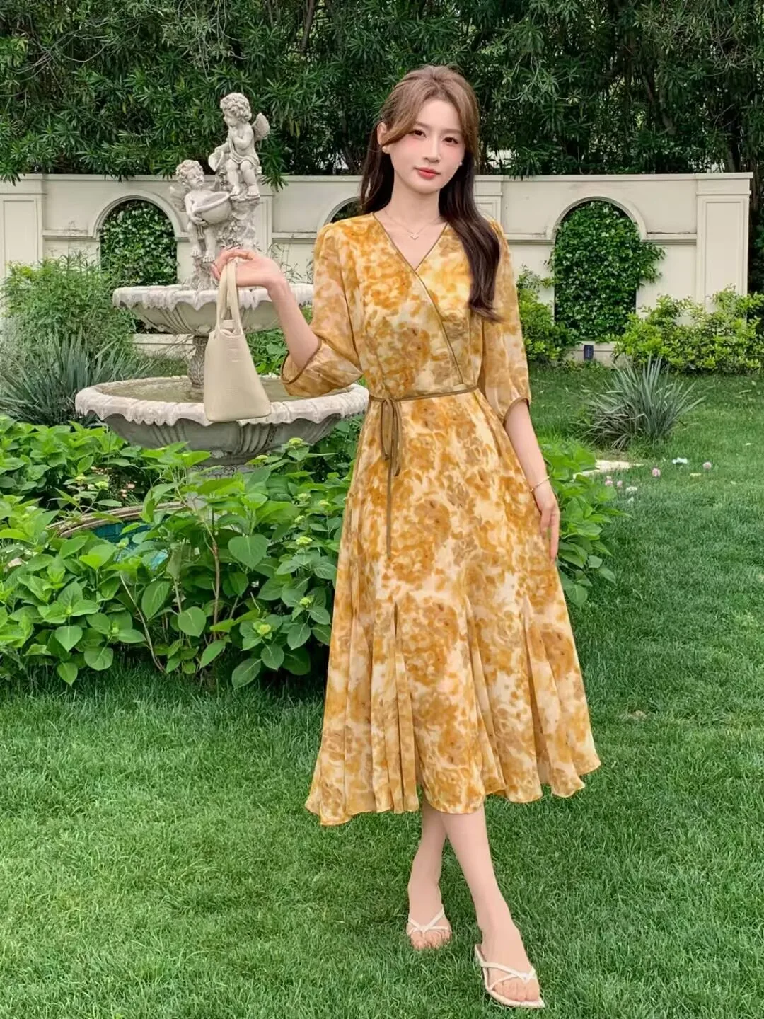Golden Watercolor Wrap Midi Dress + Slim Self-Tie Belt + Cream Mini Top-Handle Bag + Delicate Pendant Necklace + White Strappy Kitten-Heel Sandals