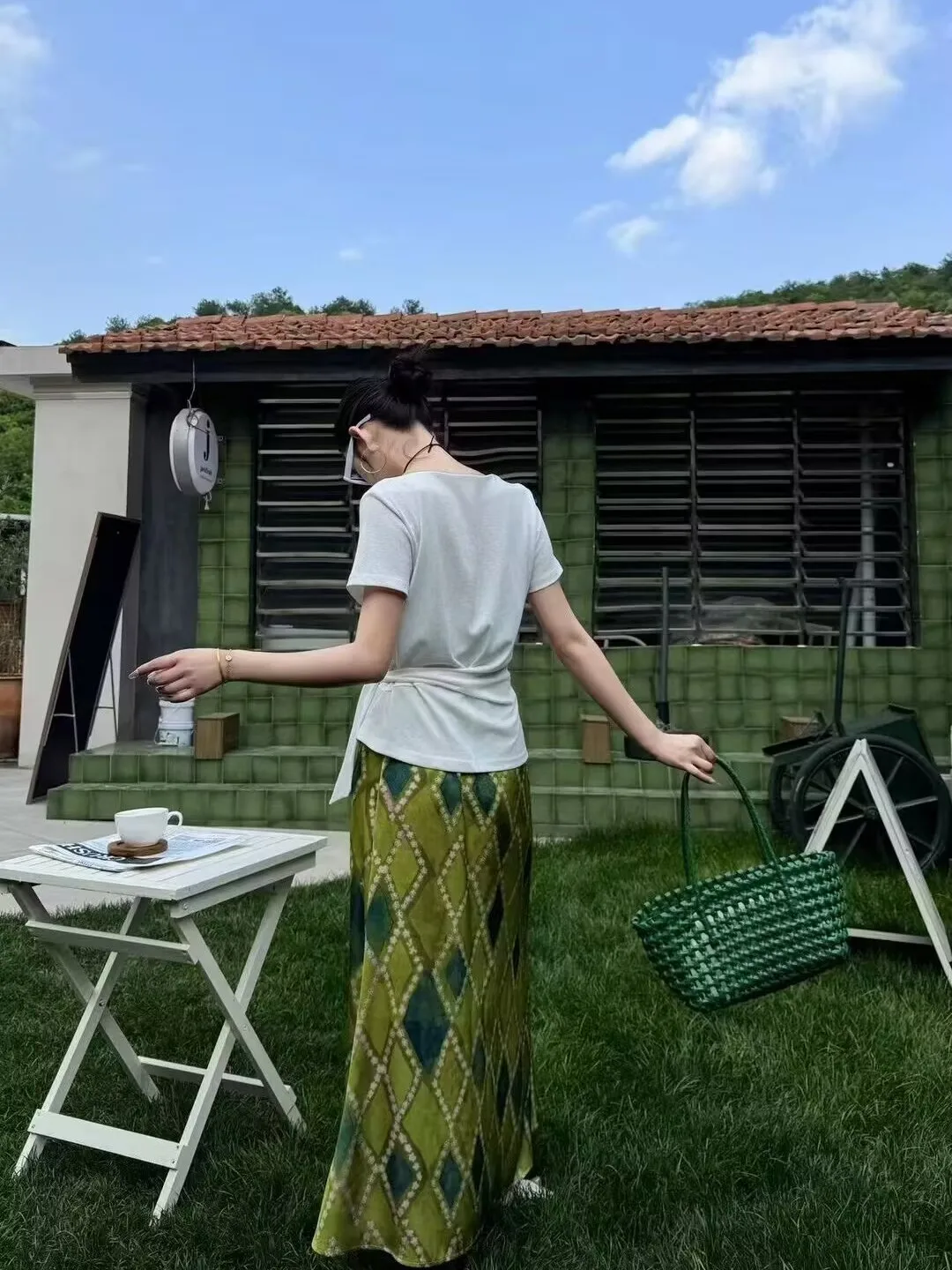 White Wrap-Waist Tee + Green Diamond Maxi Skirt + Green Woven Tote + Slim Black Sunglasses + White Slip-On Sneakers