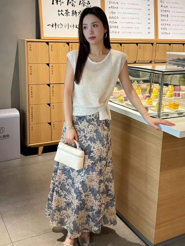Cream Sleeveless Knit Top + Blue-Beige Floral Maxi Skirt + Structured Cream Mini Bag + Silver Hoop Earrings + Brown Pointed Flats