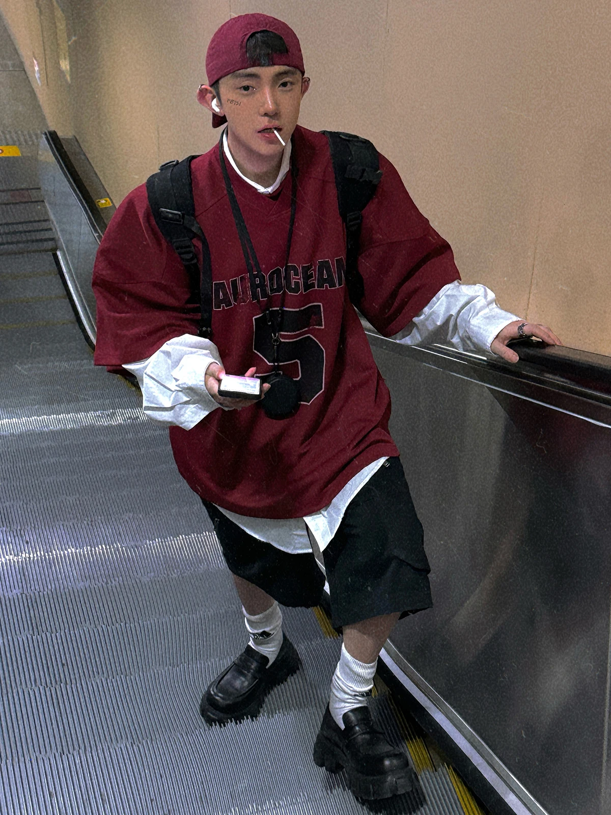 Backwards Cap + Oversized Varsity Jersey + Layered White Poplin Shirt + Black Tech Shorts + Chunky Lug-Sole Loafers