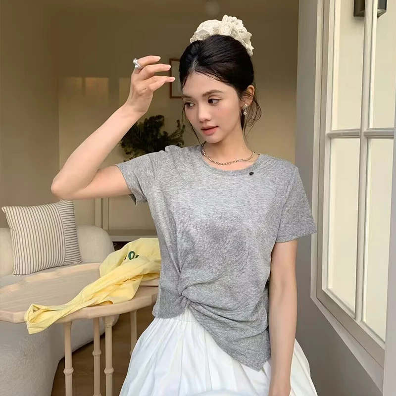 Lace scrunchie bun + grey twist-front tee + white pleated midi skirt