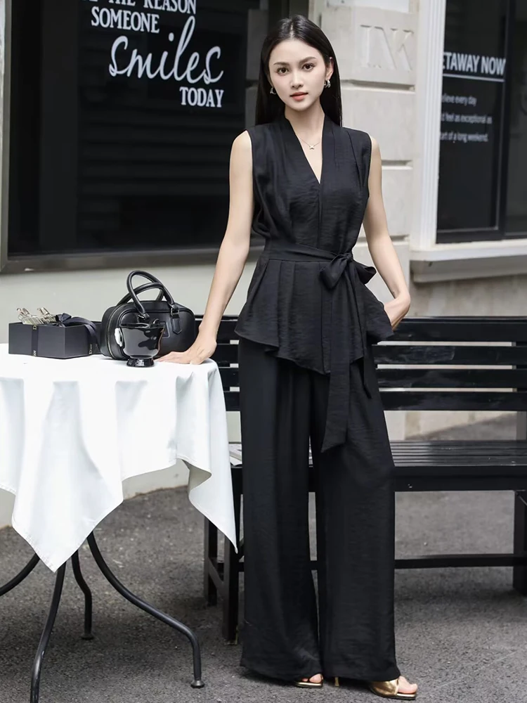 Black peplum sleeveless top + black wide-leg trousers + gold sandals
