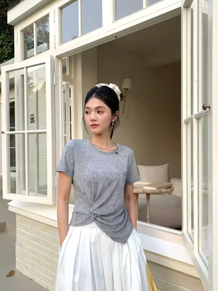 Lace scrunchie bun + grey twist-front tee + white pleated midi skirt