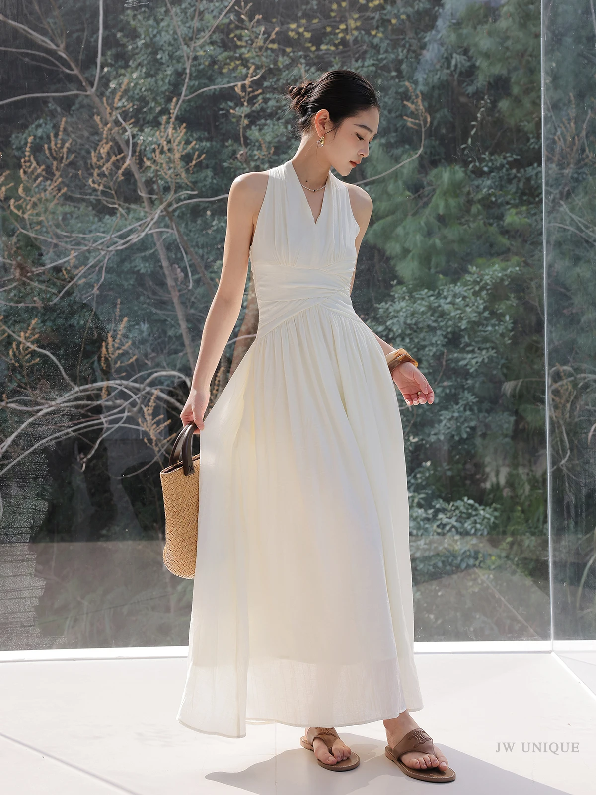 Sleek chignon + ivory halter maxi dress + rattan tote