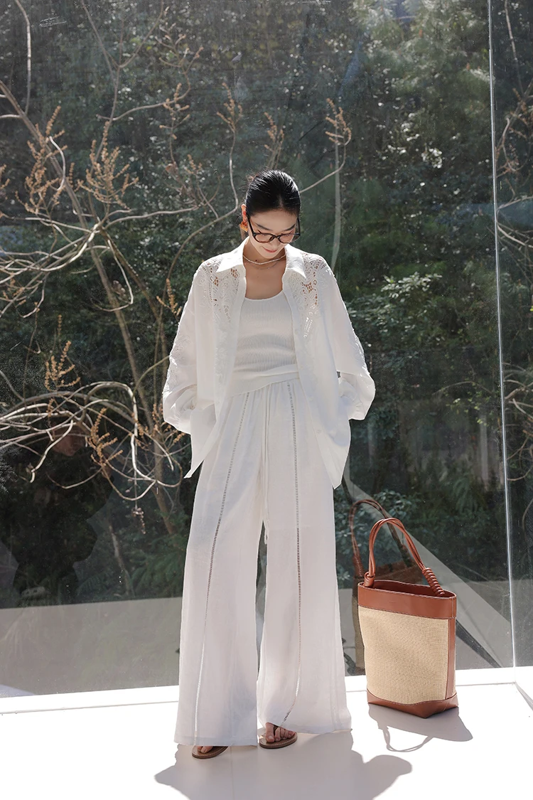 Slick bun + eyelet white shirt + ribbed knit tank + white wide-leg trousers + oversize straw tote
