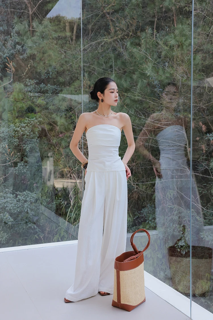 Sleek bun + white strapless top + white wide-leg trousers + structured two-tone tote