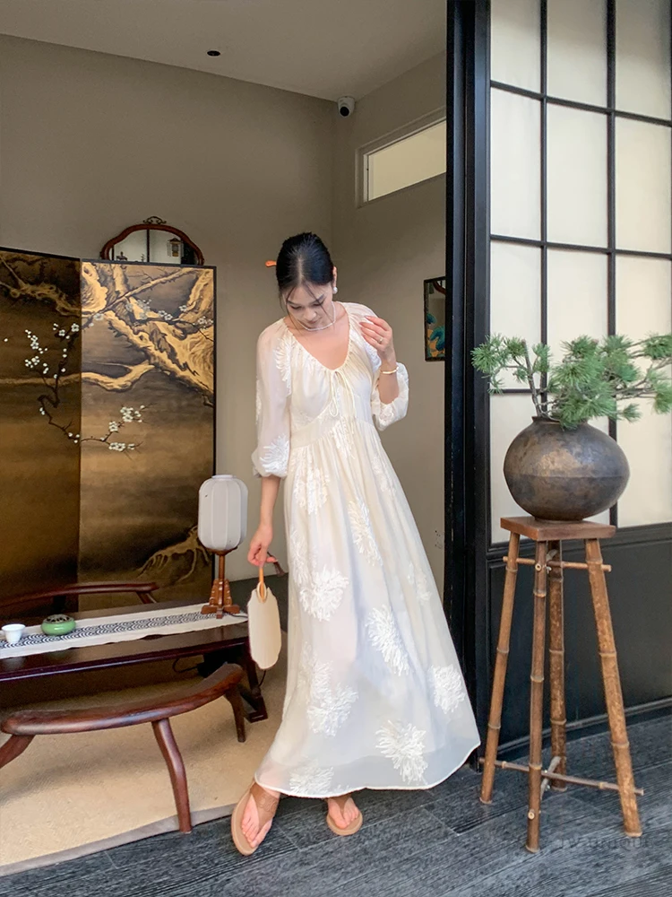 Sleek center-part bun + cream organza balloon-sleeve dress + shell fan