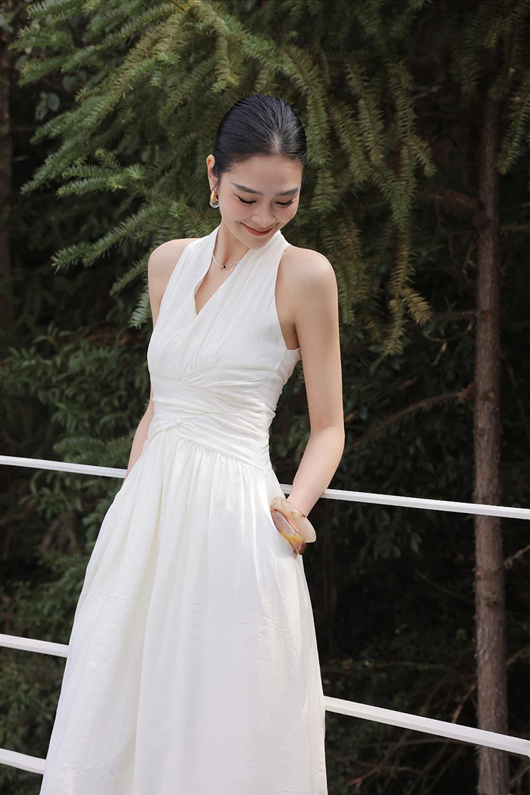Sleek bun + strapless white column dress + woven half-moon tote
