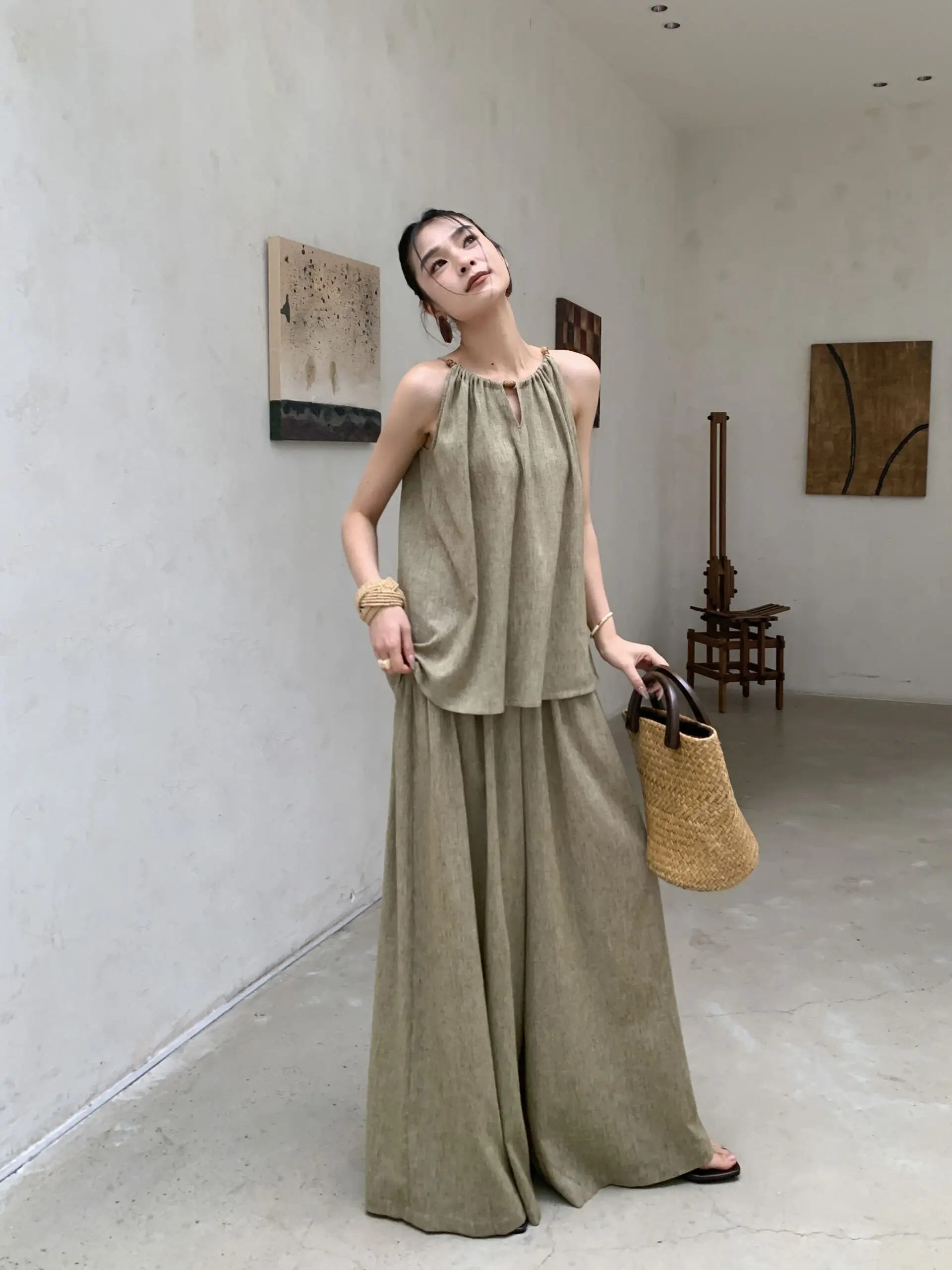 Slick ponytail + black jersey off-shoulder top + vertical-stripe linen palazzos + straw boater