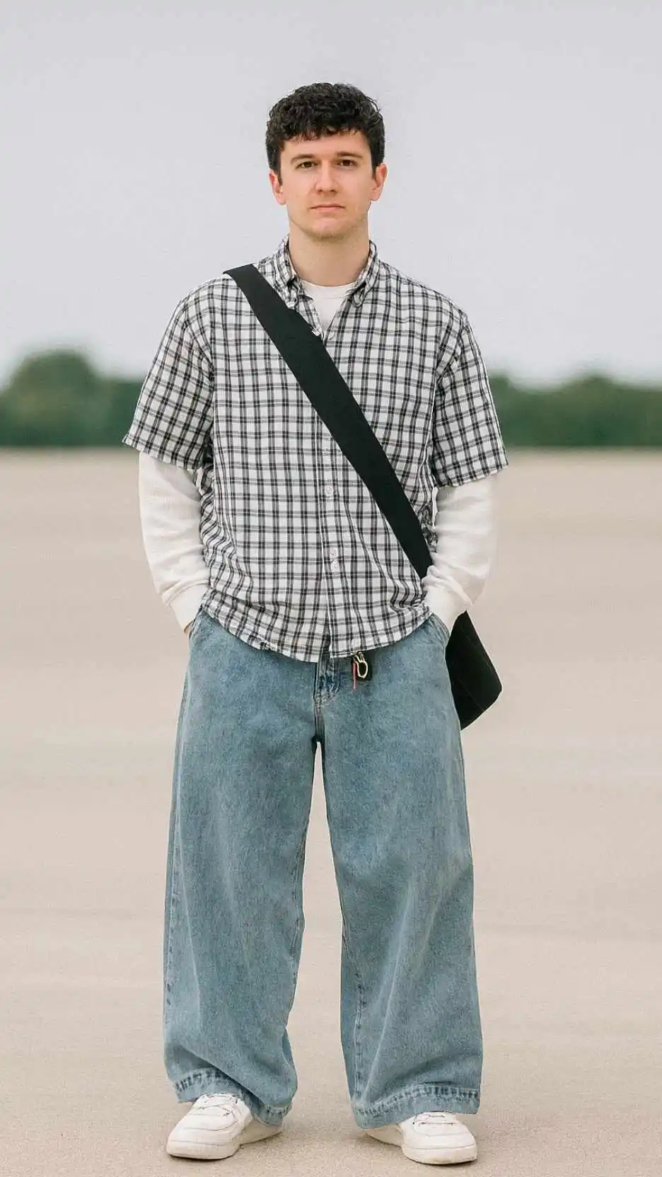 Black‑White Check Shirt + White Long‑Sleeve Layer + Light‑Blue Mega‑Jeans + White Skate Sneakers + Black Crossbody Sling + Color‑Bead Keychain