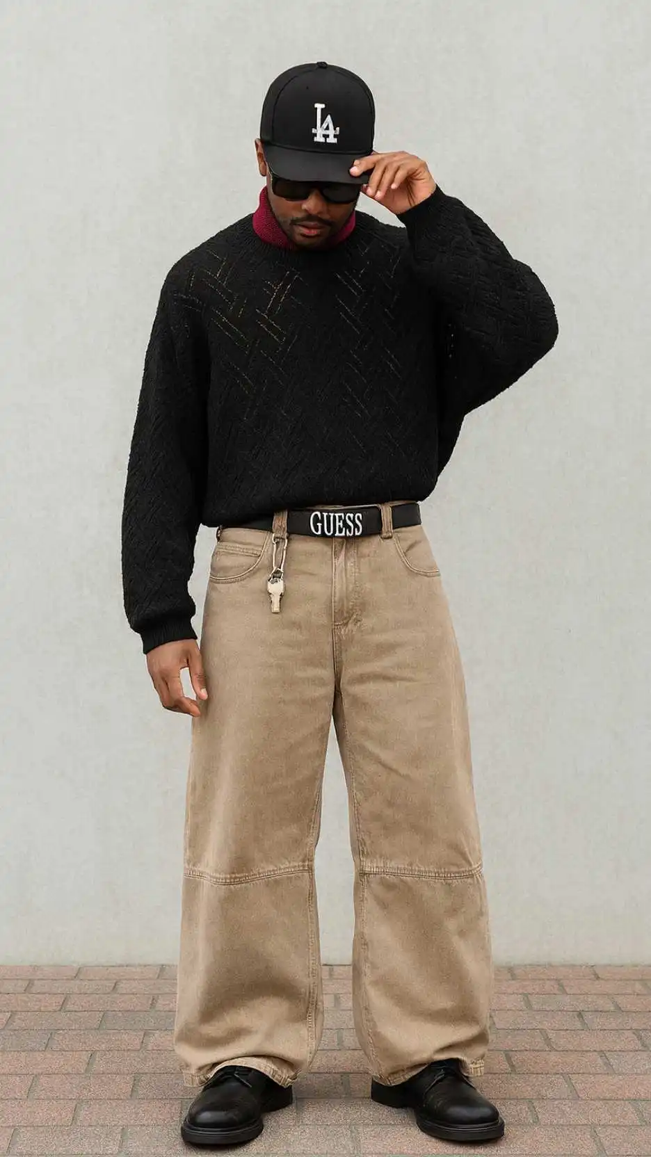 Black LA Cap + Oversized Black Sweater + Beige Wide-Leg Jeans + Black Boots + Guess Belt